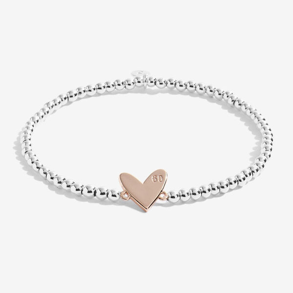Image of the 60th Birthday Bracelet out of the packaging. Highlights the golden, heart-shaped charm. 